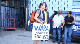 Pictured: A protester stands outside the Julius E. Sprauve School on St. John, where the Virgin Islands Water and Power Authority held a Town Hall on St. John last night.