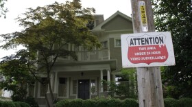 A sign in front of this large house warns of 24 hour video surveillance.