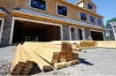 FILE - Lumber is piled at a housing construction site 