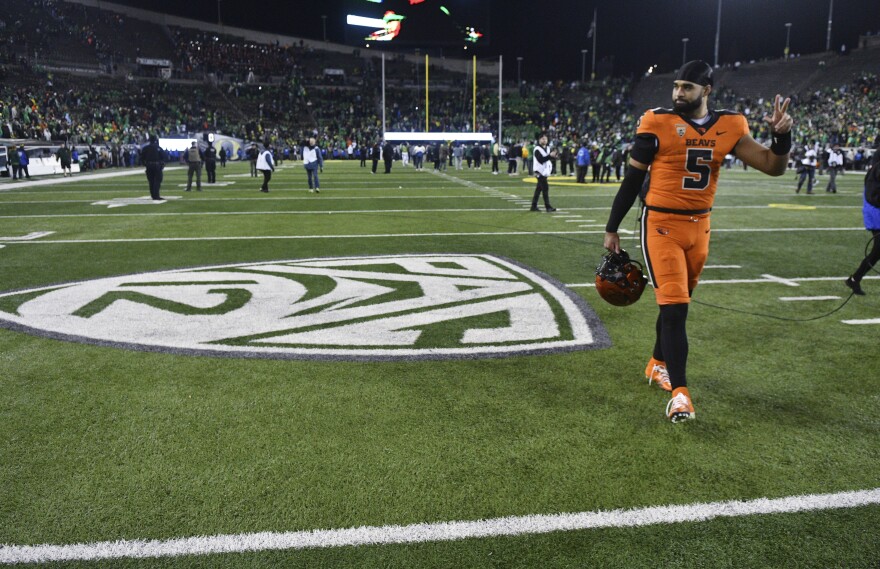 Oregon State quarterback DJ Uiagalelei (5) walks by the Pac-12 logo and waves to fans after the team's NCAA college football game against Oregon, Friday, Nov. 24, 2023, in Eugene, Ore.