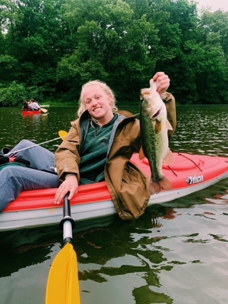 Olivia Haerr holding up fish in water