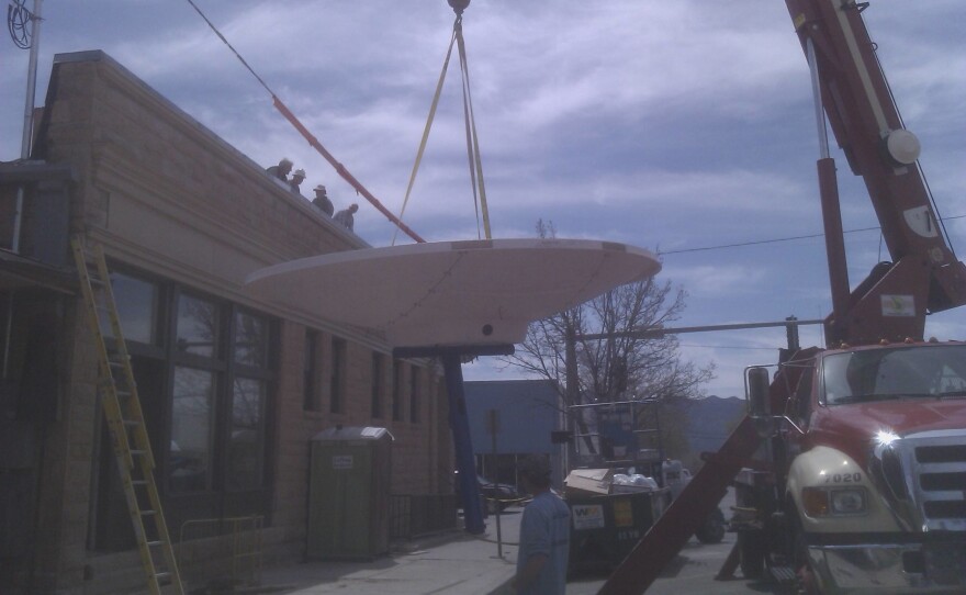 A crane lifts the KSJD satellite dish onto the roof of the Basin Bank Building during KSJD's relocation into Cortez in 2012
