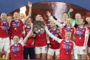 FILE - Arsenal's team captains Kin Little, left, and Leah Williamson, right, lift the trophy after winning the Women's Champions Cup final soccer match between Arsenal FC and SC Corinthians in London, Sunday, Feb. 1, 2026.
