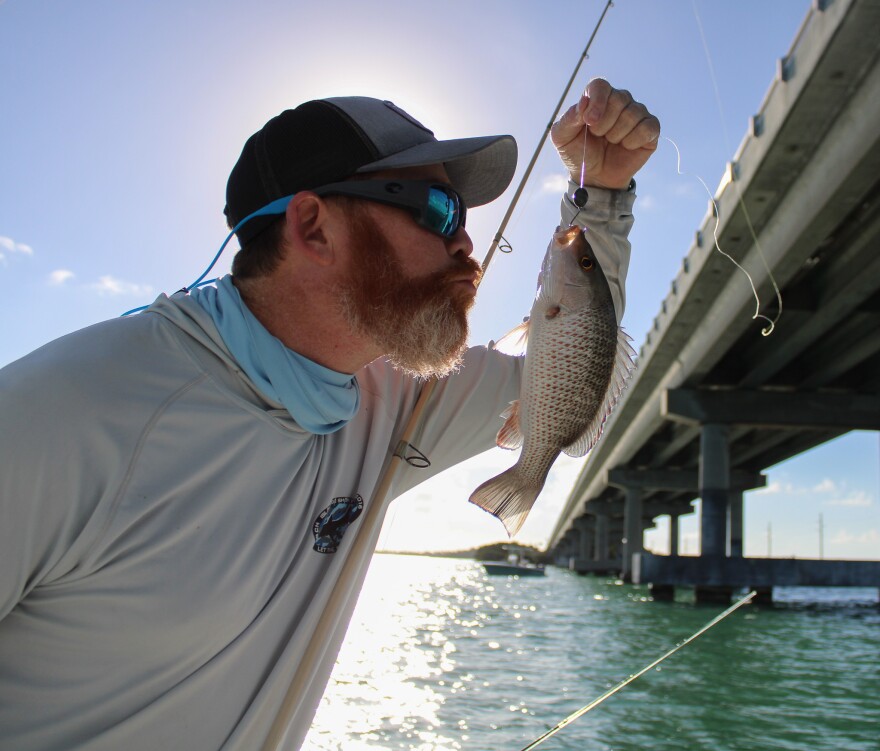 Friedman pretends to kiss his fresh catch from the shallows of Islamorada, Fla., on Monday, Jan. 2, 2023.