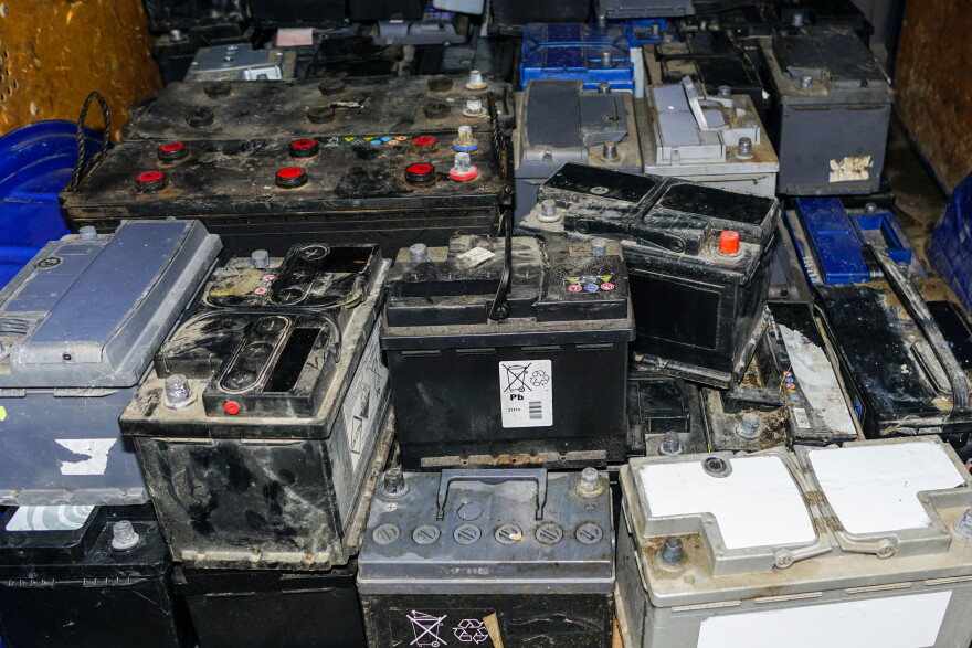 Pallet with used car batteries waiting to be recycled in an environmentally harmful scrap yard