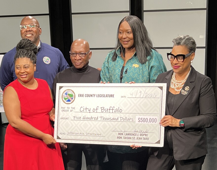 Larry Stitts (wearing turtleneck) and Zeneta Everhart (green jacket) as lawmakers present funding for the Jefferson Avenue Streetscape Project. 