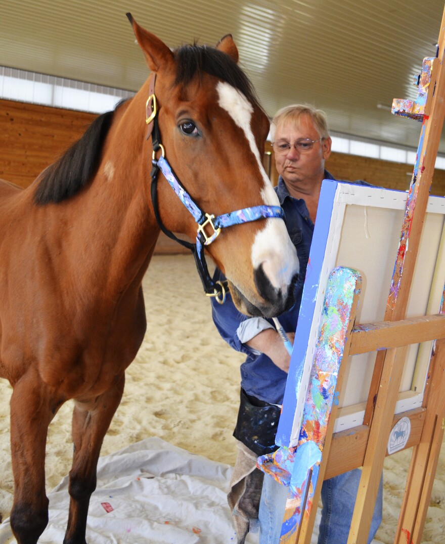 Metro wields a paintbrush as owner Ron Krajewski looks on at Motters Station Stables in Rocky Ridge, Md.