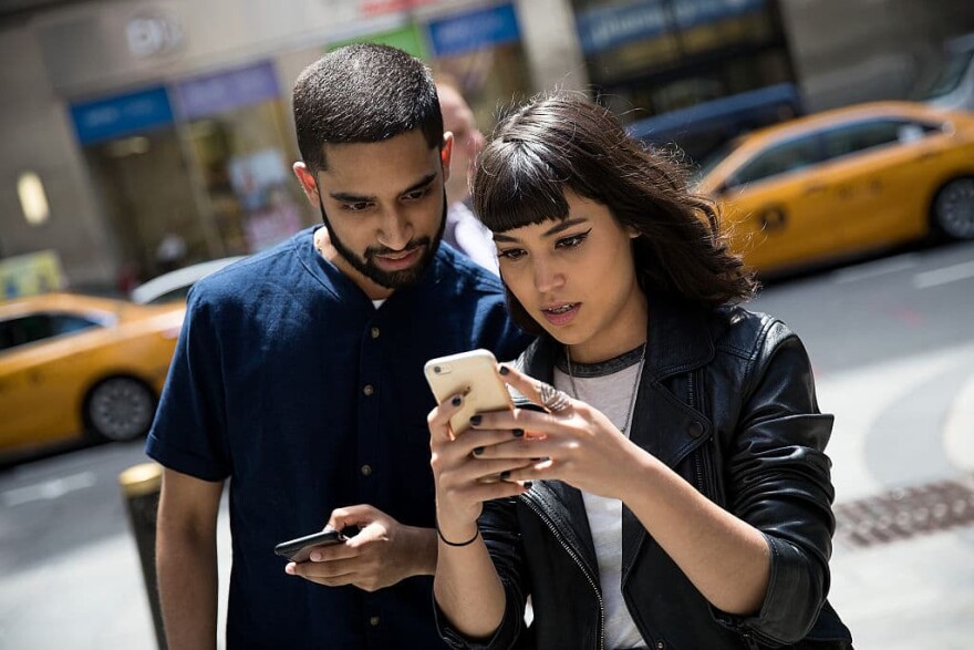 Left to right: Sameer Uddin and Michelle Macias play Pokemon Go on their smartphones outside of Nintendo's flagship store, July 11, 2016 in New York City.  The success of Nintendo's new smartphone game, Pokemon Go, has sent shares of Nintendo soaring. (Drew Angerer/Getty Images)