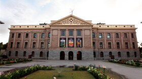 The outside of a large building with columns, made of brick and stone.