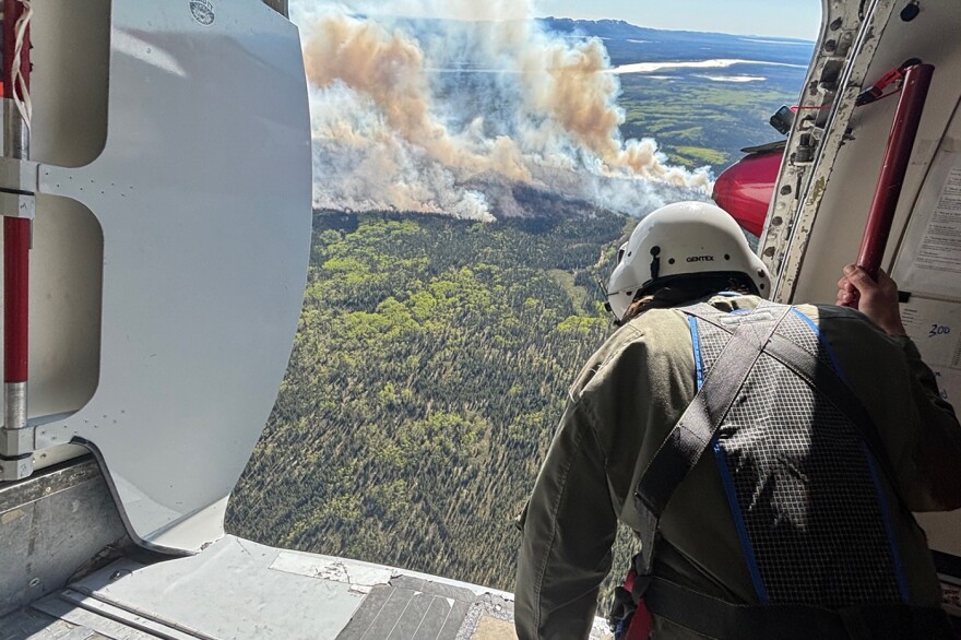 Alaska smokejumper spotter Isaiah Fischer looks down on the Kapsheut Fire as he sizes up the scenario for a fire jump by 12 smokejumpers on June 4, 2026.