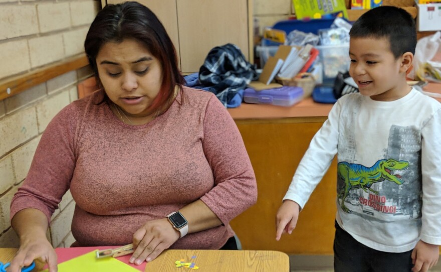 A little boy helps a teacher put together name tags at LEAP Academy's Nuestra Escuelita, which is housed in St. Luke's Episcopal Church in Durham.