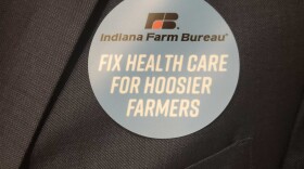 Indiana Farm Bureau members wear stickers to show support for a bill that would allow the organization to offer health benefit plan.