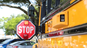 Primer plano de una cámara de seguridad en un autobús escolar con una señal de stop.