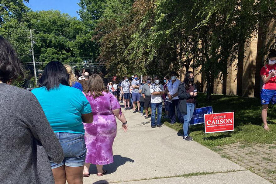 Voters stand in line waiting to vote outside of the Broad Ripple High School building.