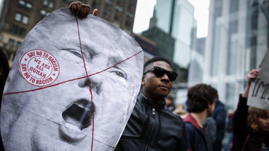 A man holds a sign as he takes part in a protest against Republican presidential front-runner Donald Trump in New York on March 19.