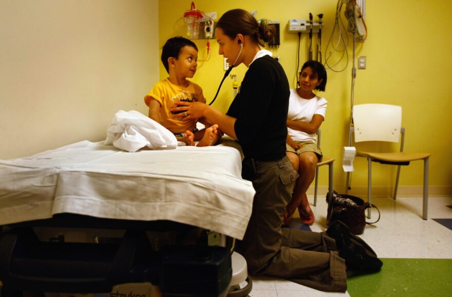 Resident nurse Amy Grover checks the heart rate of a 3-year-old in the emergency room of the Children's Hospital in Aurora, Colorado.