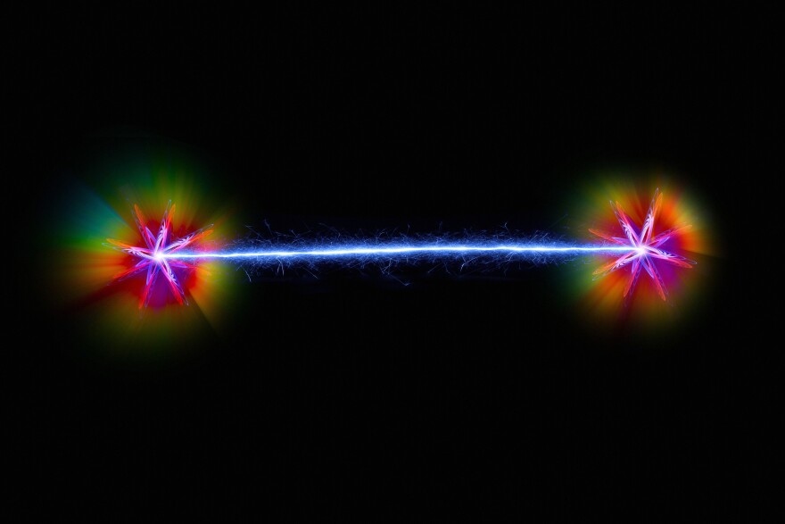 Quantum entanglement. Conceptual artwork of a pair of entangled quantum particles or events interacting at a distance. Quantum entanglement is one of the consequences of quantum theory.