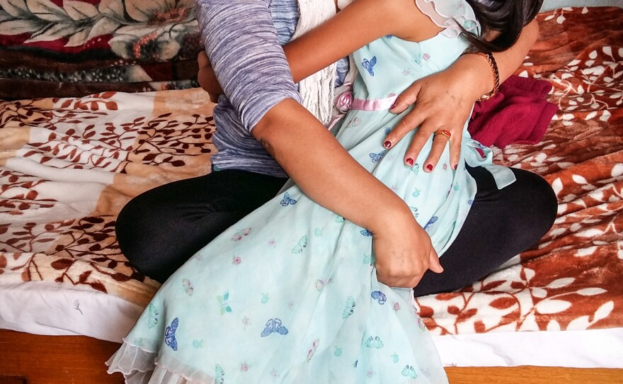 Chheten Drolma and her niece embrace. Drolma's sister — the little girl's mother — died in the disaster. Drolma is now in the process of adopting her late sister's three daughters.
