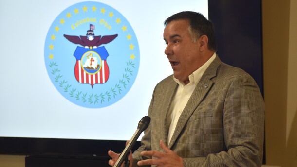 Columbus Mayor Andrew Ginther talks at a podium.