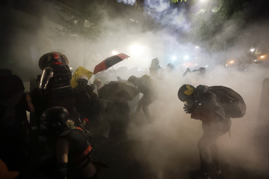 In this July 26, 2020, file photo, federal officers launch tear gas at demonstrators during a Black Lives Matter protest at the Mark O. Hatfield U.S. Courthouse in Portland, Ore.