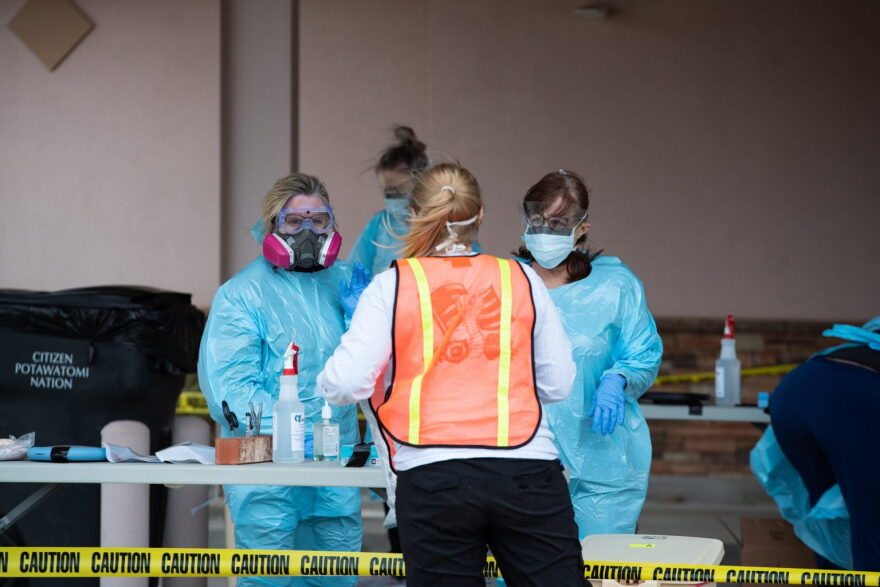Nurses talk to another worker at a drive-through testing site in Shawnee where at least 30 people were tested for coronavirus on April 2.