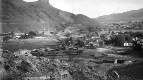 A black and white historic photo of a small town near the foothills.