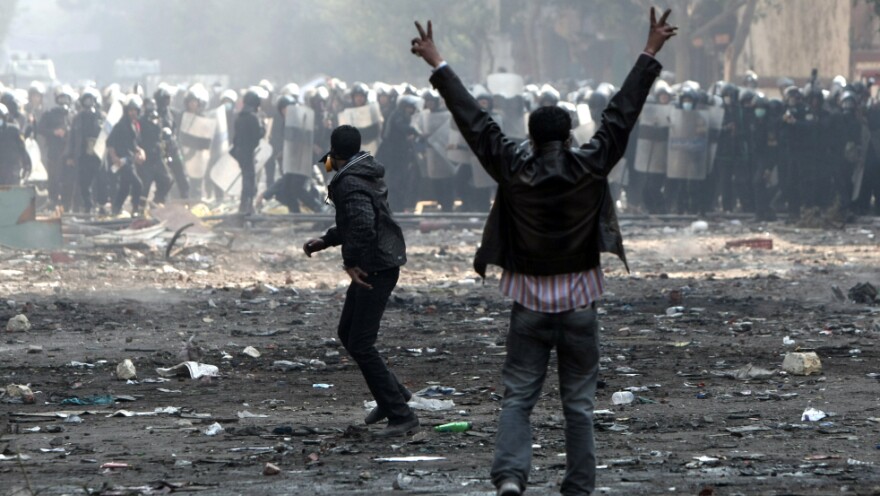 An Egyptian protester flashes the victory sign during clashes with riot police near Cairo's Tahrir Square on Wednesday. The clashes in recent days have clouded Egypt's future as it prepares for elections on Monday.