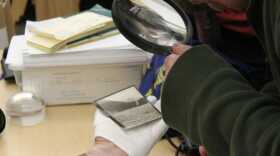 someone looks with a magnifying glass at a black and white image