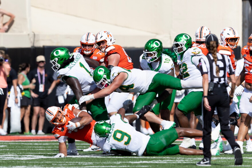 Football players tumble at the end of a play.