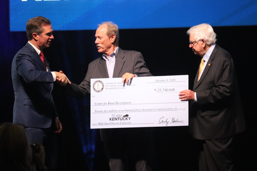 Gov. Andy Beshear (left) and U.S. Rep. Hal Rogers (right), present a check to Lonnie Lawson, director of the Center for Rural Development.