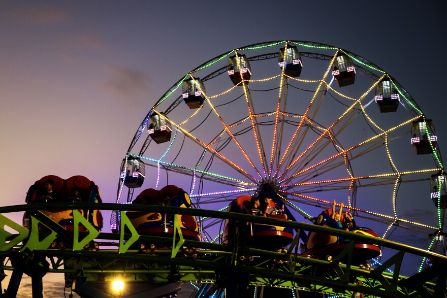 FILE: The sun drifts down, the lights ignite, and the ride lines begin to stretch as the first full night of the Woodstock Fair comes to life.