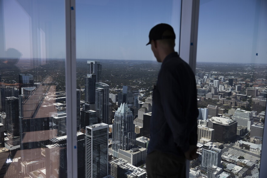 Turner Kerr, a project manager at DPR Construction, looks out of the penthouse windows of the Waterline across downtown Austin.