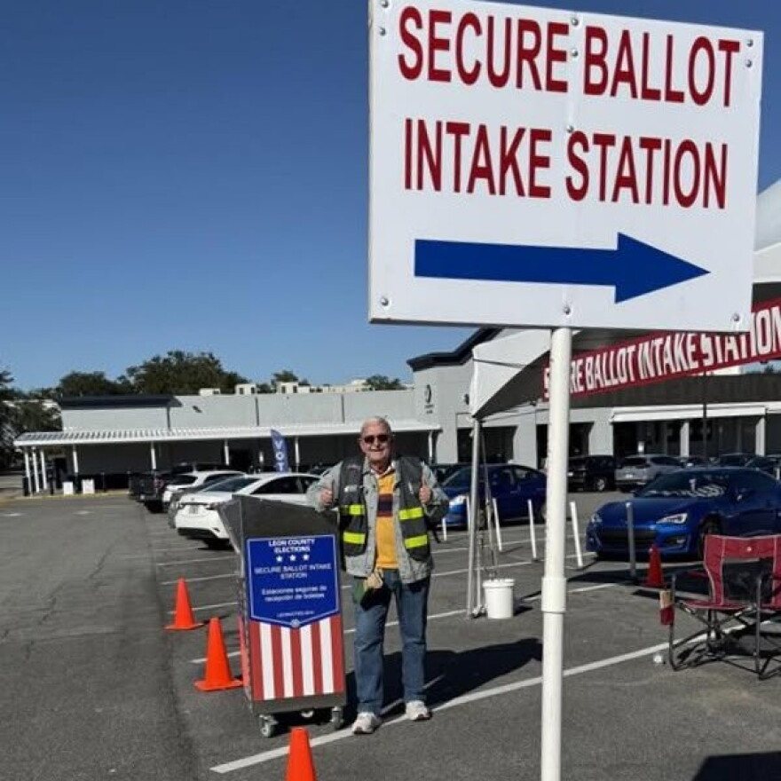 A Leon poll worker smiles and shows thumbs up 