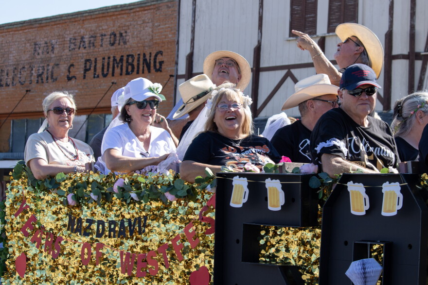 Katherine Maler, second from left, rides on a parade float in the annual Westfest parade Saturday with other couples married in 1976. Westfest is celebrated its 50th anniversary over the weekend.