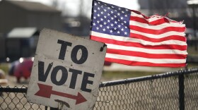 A vote sign and American flag are shown outside a Michigan primary election location in Dearborn, Mich., Tuesday, Feb. 27, 2024.