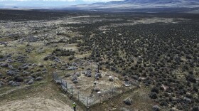 An employee stands near the Lithium Nevada Corp. mine site at Thacker Pass on April 24, 2023, near Orovada, Nev. The huge lithium mine under construction is at the center of a dispute over President Joe Biden's clean energy agenda. (AP Photo/Rick Bowmer)