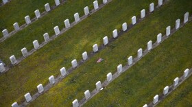 An American flag is shown between rows of headstones in the Veterans section on Thursday, March 1, 2018, at Evergreen Washelli Cemetery in Seattle. 