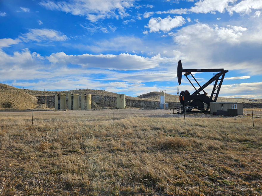 A mechanical device with the ability to pump up and down into the ground is set up in an open, arid landscape.