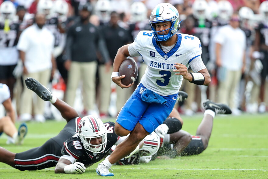 Kentucky quarterback Kenny Minchey (3) runs for a first down past South Carolina defensive lineman Anthony Addison (40) during the first half of an NCAA college football game Saturday, Oct. 3, 2026, in Columbia, S.C. (AP Photo/Artie Walker Jr.)
