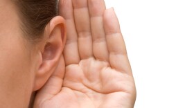 Girl listening with her hand on an ear