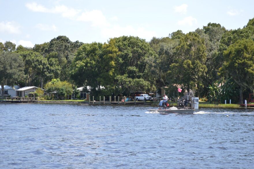 A worker applies herbicides to hydrilla from his airboat on Lake Rousseau. The herbicides are spread from the orange hose on his boat to the base of the hydrilla. (Cecilia Mazanec/WUFT News)