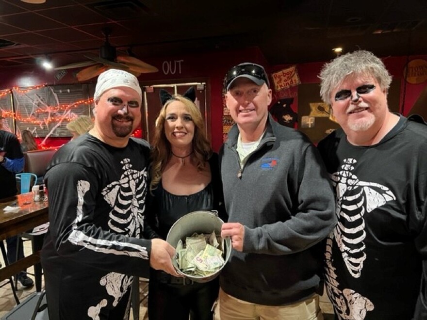 Shawn Black hands the donation bucket to Keith Kidd of Honor Flight Kentucky