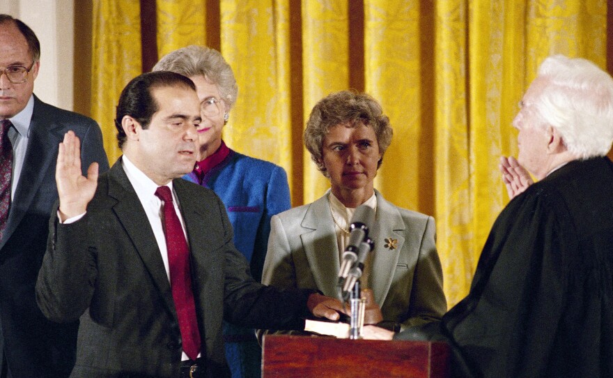 In this Sept. 26, 1986, file photo, retiring Chief Justice Warren Burger (right) administers an oath to Associate Justice Antonin Scalia, as Scalia's wife, Maureen, holds the bible during ceremonies in the East Room of White House.