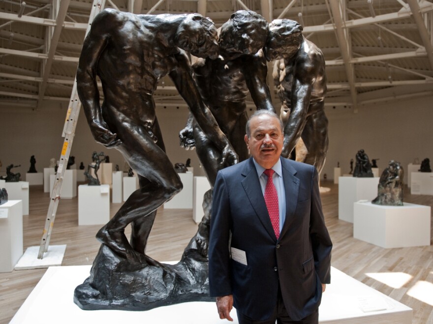 Carlos Slim invested more than $800 million in the Soumaya Museum, the second museum opened by the telecommunications mogul. Here, he stands with Auguste Rodin's <em>The Three Shades</em> on March 28, the eve of the opening.