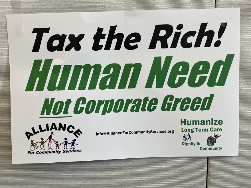A sign saying Tax the Rich. Human Need Not Corporate Greed.
