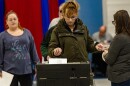 A voter submits her ballot into the ballot machine at the Bishop Leo E. O’neil Youth Center in Manchester. (Jesse Costa/WBUR)