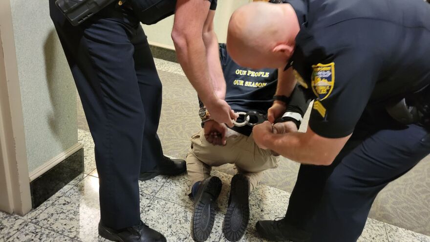 Ben Frazier is handcuffed after a disturbance in City Council chambers.