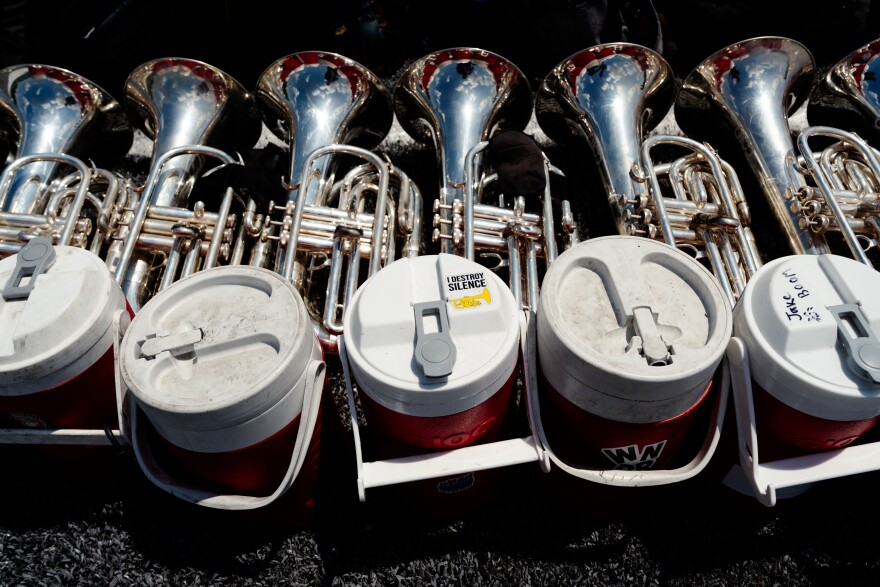 Euphoniums and baritones sit stacked beside matching red water jugs during a Boston Crusaders rehearsal on Tuesday, July 22, 2025, at Pattonville High School in Maryland Heights.