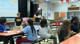 Kids at Templeton Elementary School collect supplies to start a painting activity.