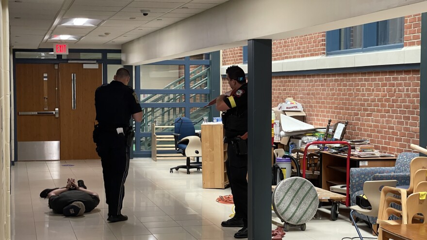 Two police officers guard the subdued gunman during an active shooter drill in Waterford.